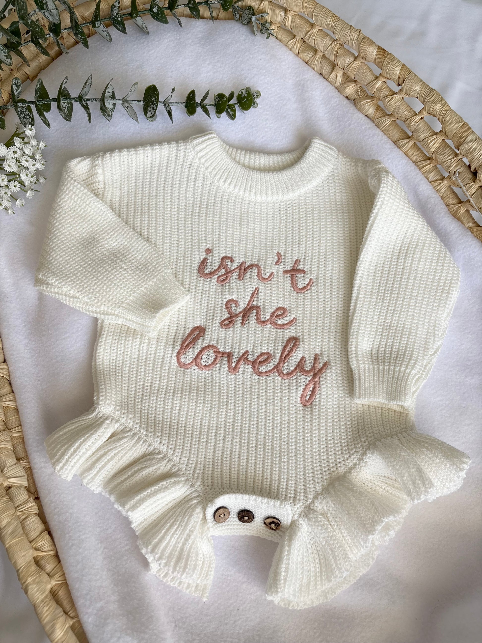 White baby romper with 'isn't she lovely' text on a white background