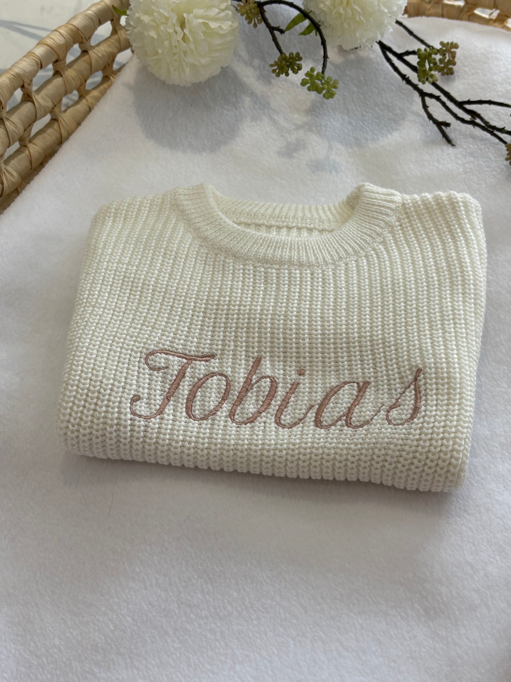 Close up of personalised embroideredname on baby romper.