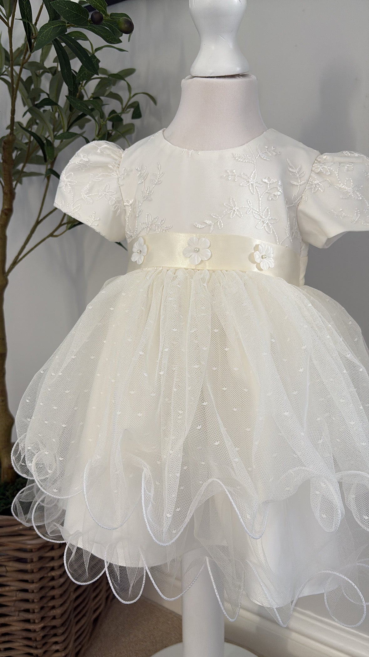 Ivory baby girl christening dress with embroidered floral bodice, pearl flower details, puff sleeves and layered tulle skirt.